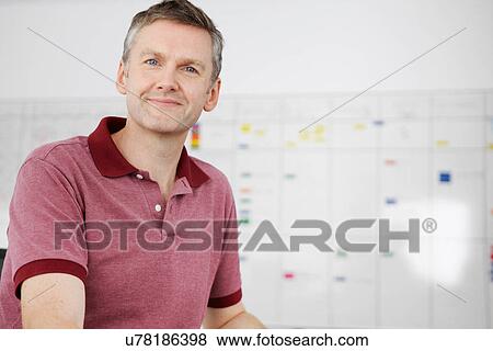 Stock Photo - Man sitting in office looking at camera. Fotosearch