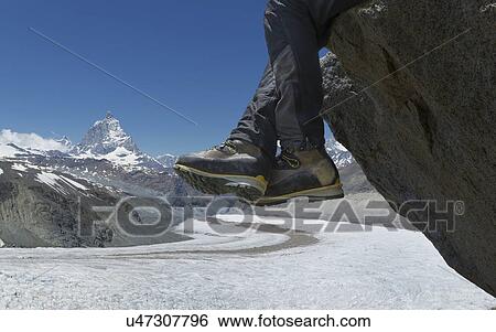 Man sitting on rock by the Matterhorn, Zermatt, Canton Wallis, Switzerland View Large Photo Image Stock Photograph - Man sitting on rock by the Matterhorn, Zermatt, Canton Wallis, Switzerland. Fotosearch