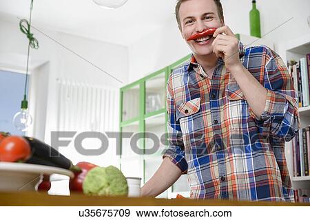 Man smelling red chili pepper View Large Photo Image Stock Photo - Man smelling red chili pepper. Fotosearch