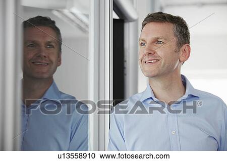 Man standing beside window, with reflection View Large Photo Image Stock Image - Man standing beside window, with reflection. Fotosearch