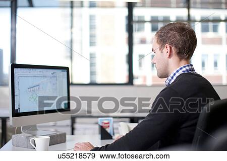 Man using computer in office View Large Photo Image Stock Photo - Man using computer in office. Fotosearch