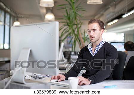Stock Photo - Man using computer in office. Fotosearch