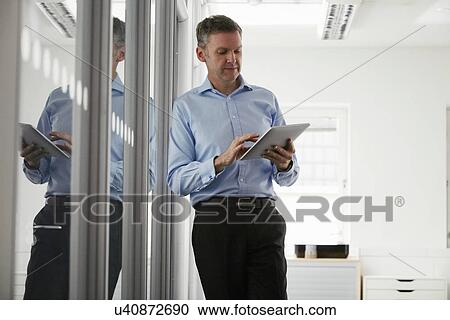 Man using digital tablet in office View Large Photo Image Stock Image - Man using digital tablet in office. Fotosearch