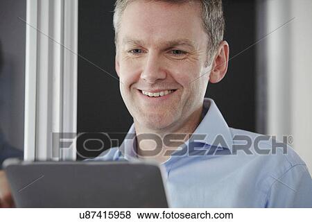 Man using digital tablet in office View Large Photo Image Stock Photo - Man using digital tablet in office. Fotosearch