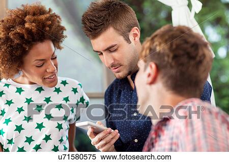 Man using smartphone with friends View Large Photo Image Stock Photography - Man using smartphone with friends. Fotosearch
