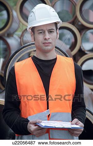 Stock Photo - Manual worker wearing high vis vest and hard hat. Fotosearch
