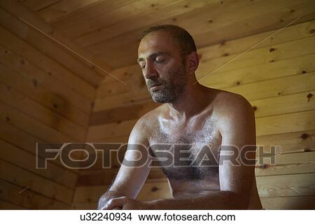 Picture - Mature man sitting in sauna with head down. Fotosearch