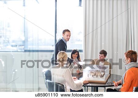 Stock Image - Meetings in architects office, looking at model. Fotosearch