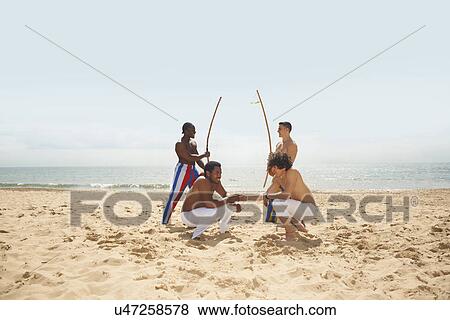 Stock Photo - Men doing capoeira on beach. Fotosearch