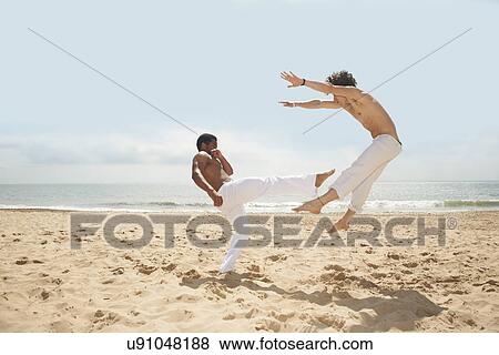 Men doing capoeira on beach View Large Photo Image Stock Photo - Men doing capoeira on beach. Fotosearch