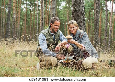 Mid adult couple foraging for mushrooms in forest View Large Photo Image Stock Image - Mid adult couple foraging for mushrooms in forest. Fotosearch
