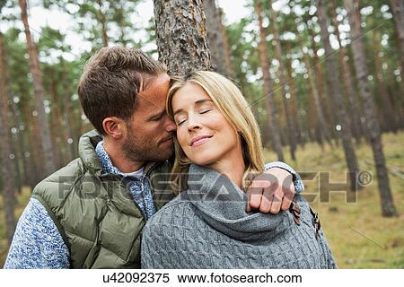 Mid adult couple hugging in forest View Large Photo Image Stock Photography - Mid adult couple hugging in forest. Fotosearch