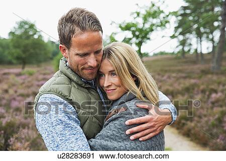 Stock Image - Mid adult couple hugging. Fotosearch