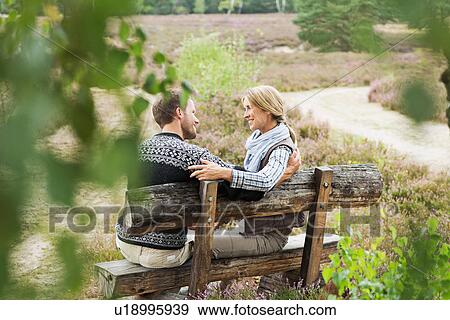 Mid adult couple on wooden bench View Large Photo Image Stock Photo - Mid adult couple on wooden bench. Fotosearch