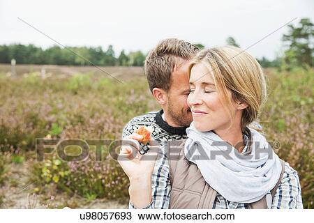 Stock Image - Mid adult couple, woman smiling with eyes closed. Fotosearch