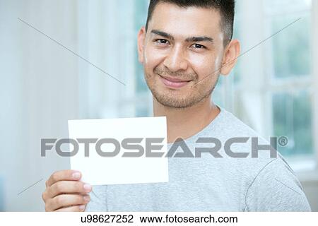 Mid adult man holding a blank card View Large Photo Image Stock Image - Mid adult man holding a blank card. Fotosearch