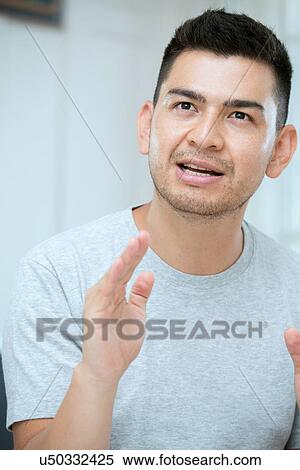 Stock Photography - Mid adult man talking. Fotosearch