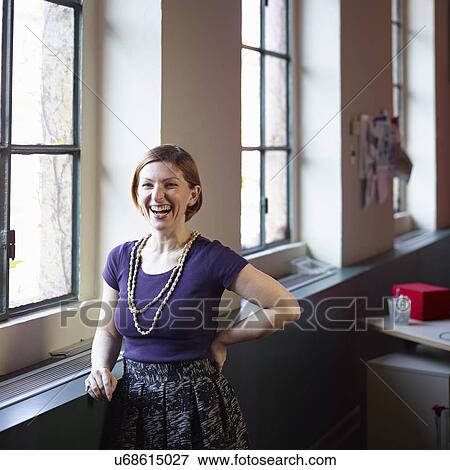 Mid adult woman by window, laughing View Large Photo Image Stock Photo - Mid adult woman by window, laughing. Fotosearch