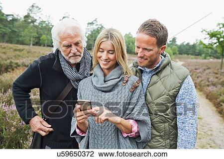 Stock Image - Mid adult woman using camera phone. Fotosearch