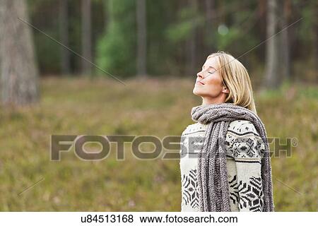 Mid adult woman wearing sweater with eyes closed View Large Photo Image Stock Photo - Mid adult woman wearing sweater with eyes closed. Fotosearch