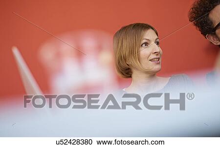 Stock Image - Mid adult woman with bobbed hair looking away. Fotosearch