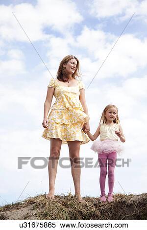 Mother and daughter holding hands on dunes, Wales, UK View Large Photo Image Stock Photography - Mother and daughter holding hands on dunes, Wales, UK. Fotosearch