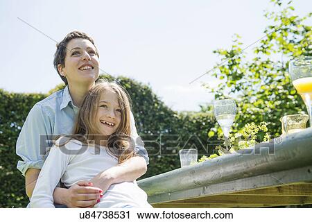 Stock Image - Mother and daughter outside, low angle. Fotosearch