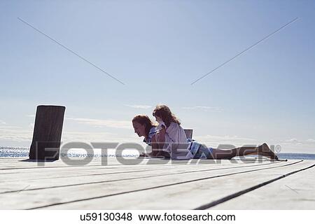 Mother and daughter playing on jetty, Utvalnas, Gavle, Sweden View Large Photo Image Stock Photo - Mother and daughter playing on jetty, Utvalnas, Gavle, Sweden. Fotosearch