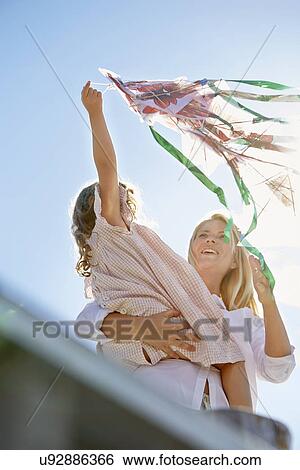 Stock Photograph - Mother and daughter playing with kite, Utvalnas, Gavle, Sweden. Fotosearch