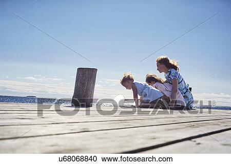 Mother and daughters playing on jetty, Utvalnas, Gavle, Sweden View Large Photo Image Stock Image - Mother and daughters playing on jetty, Utvalnas, Gavle, Sweden. Fotosearch