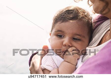Stock Image - Mother cuddling baby girl. Fotosearch