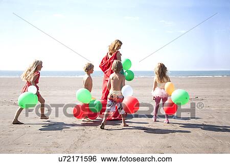 Mother with four childen on beach with balloons, Wales, UK View Large Photo Image Stock Photograph - Mother with four childen on beach with balloons, Wales, UK. Fotosearch