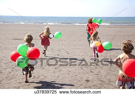 Mother with four childen on beach with balloons, Wales, UK View Large Photo Image Stock Photography - Mother with four childen on beach with balloons, Wales, UK. Fotosearch