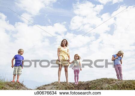 Mother with three children on dunes, Wales, UK View Large Photo Image Picture - Mother with three children on dunes, Wales, UK. Fotosearch