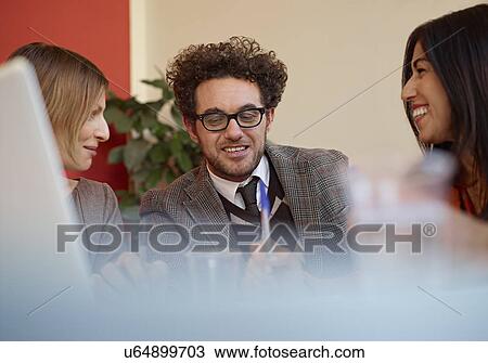Stock Image - Office colleagues in meeting. Fotosearch