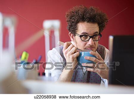 Stock Photo - Office worker eating breakfast cereal at desk. Fotosearch
