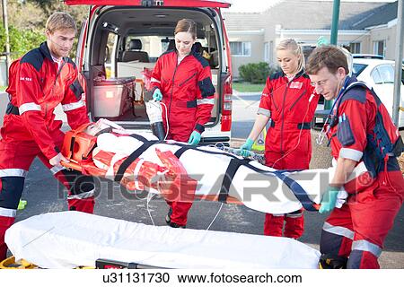 Paramedics lifting woman on stretcher onto bed View Large Photo Image Stock Image - Paramedics lifting woman on stretcher onto bed. Fotosearch