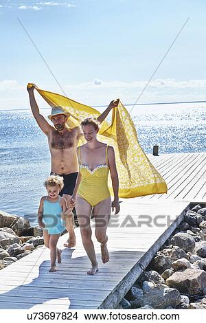 Picture - Parents and two daughters on pier, Utvalnas, Gavle, Sweden. Fotosearch