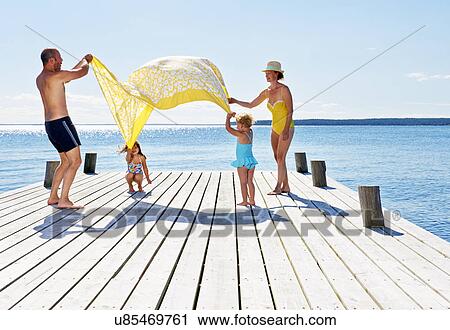 Parents and two young girls playing on pier, Utvalnas, Gavle, Sweden View Large Photo Image Stock Image - Parents and two young girls playing on pier, Utvalnas, Gavle, Sweden. Fotosearch