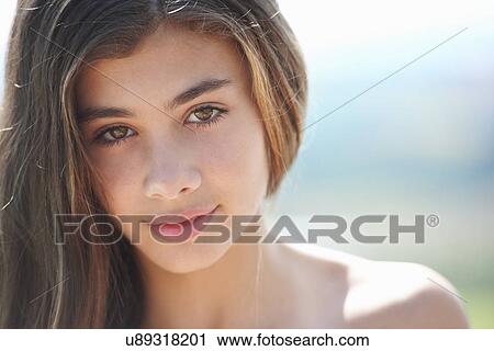Stock Image - Portrait of brunette teenage girl looking at camera. Fotosearch