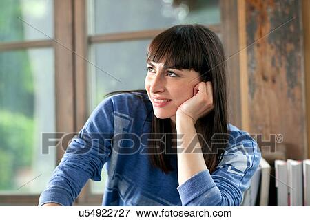 Stock Photo - Portrait of brunette woman smiling with hand on chin. Fotosearch