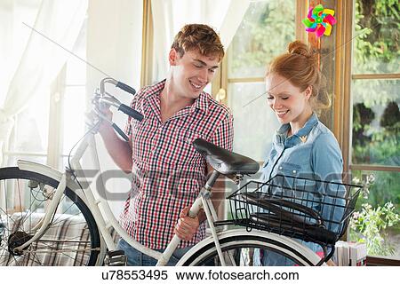Portrait of couple holding bicycle View Large Photo Image Stock Photography - Portrait of couple holding bicycle. Fotosearch