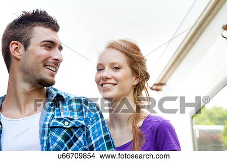 Portrait of couple smiling, low angle View Large Photo Image Picture - Portrait of couple smiling, low angle. Fotosearch