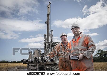 Stock Image - Portrait of drilling rig workers in hard hats and workwear. Fotosearch