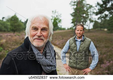 Portrait of father with adult son in background, smiling View Large Photo Image Stock Photo - Portrait of father with adult son in background, smiling. Fotosearch