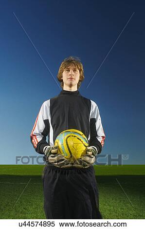 Stock Photography - Portrait of galkeeper holding football. Fotosearch