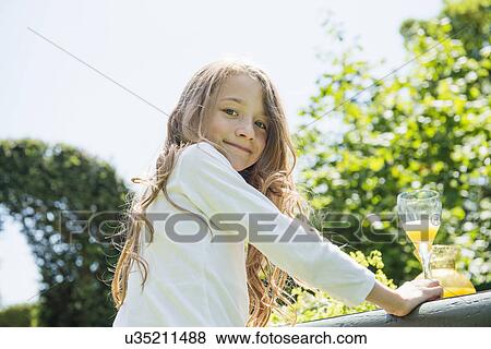 Stock Photo - Portrait of girl looking at camera, smiling. Fotosearch