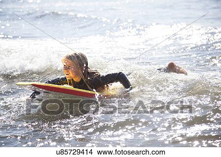 Portrait of girl on surfboard, Wales, UK View Large Photo Image Picture - Portrait of girl on surfboard, Wales, UK. Fotosearch