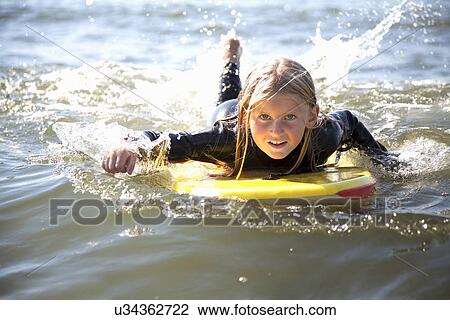 Portrait of girl on surfboard, Wales, UK View Large Photo Image Stock Image - Portrait of girl on surfboard, Wales, UK. Fotosearch