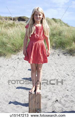 Portrait of girl standing on wooden groyne, Wales, UK View Large Photo Image Stock Image - Portrait of girl standing on wooden groyne, Wales, UK. Fotosearch